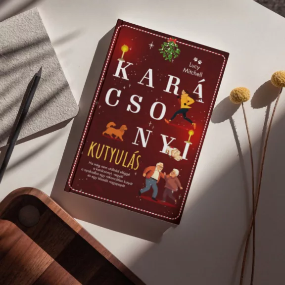 A képen a Karácsonyi kutyulás című könyv látható a háttérben egy spániel.