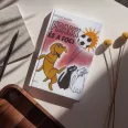 A képen a Frakk és a foci című könyv látható a háttérben egy vizsla.