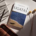 A képen az Ugatás című könyv látható a háttérben egy kutyáját ölelő emberrel.