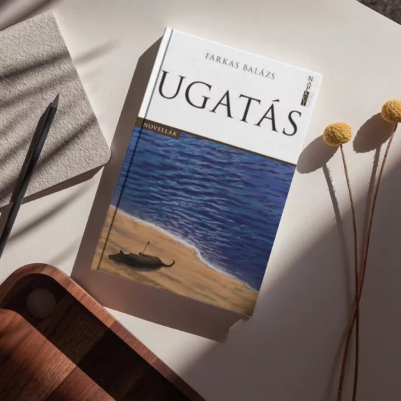 A képen az Ugatás című könyv látható a háttérben egy kutyáját ölelő emberrel.