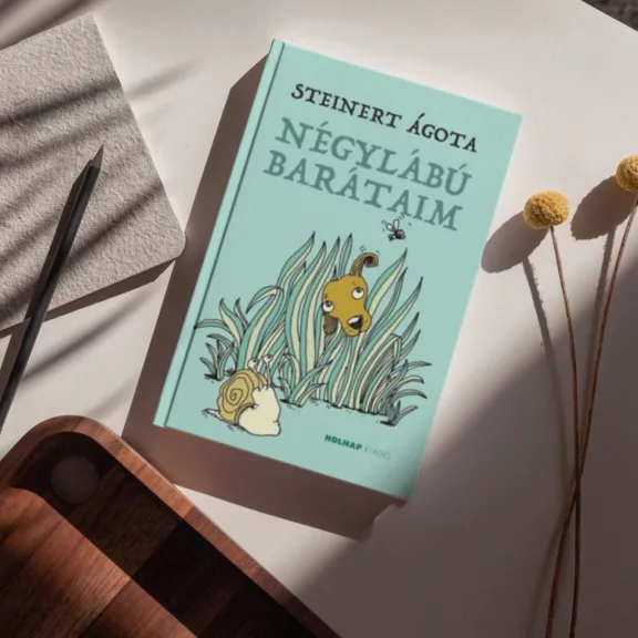 A képen a Négylábú barátaim című könyv látható a háttérben egy kutyával és egy csigával.