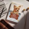 A képen az Egy kutya küldetése Max története című könyv látható a háttérben egy yorkshire terrier.