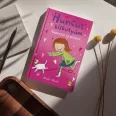 A képen a Gézengúz új otthona című könyv látható a háttérben egy kislány és kutyája.