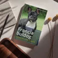 A képen a Francia buldog című könyv látható a háttérben egy francia buldog.