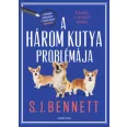 A képen A három kutya problémája című könyv látható a háttérben két kutyával.