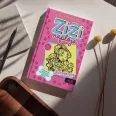 A képen az Egy Zizi naplója 10 című könyv látható a háttérben kutyákkal.