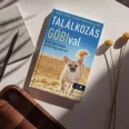 A képen a Találkozás Góbival című könyv látható a háttérben egy csivava.