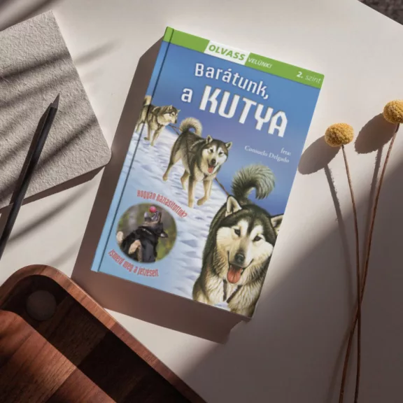 A képen az Olvass velünk 2 Barátunk a kutya című könyv látható a háttérben egy huskyval.