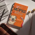 A képen az Egy mopsz naplója című könyv látható a háttérben mopszokkal.