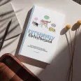 A Kutyanyelv Ebtestbeszéd című könyv látható a képen kutyákkal a háttérben.