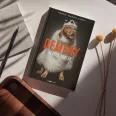 A képen a Demény - Nektek ugatok című könyv látható egy kutyával a háttérben.