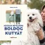 A képen a Hogyan neveljünk boldog kutyát című könyv látható a háttérben egy kutyáját ölelő nő.