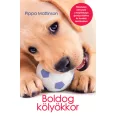 A képen a Boldog kölyökkor című könyv látható a háttérben egy labrador kölyök.