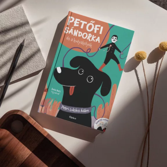 A képen a Petőfi Sándorka és a kutyakölyök című könyv látható a háttérben egy labrador.