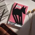 A képen a Segítség kutyás lettem című könyv látható a háttérben egy fehér kutyával.