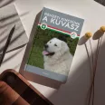 A képen a Nemzeti kincsünk a kuvasz című könyv látható a háttérben a magyar zászló színei.
