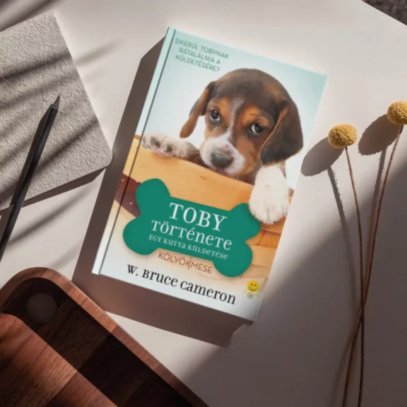 A képen az Egy kutya küldetése Toby története című könyv látható a háttérben egy beagle.