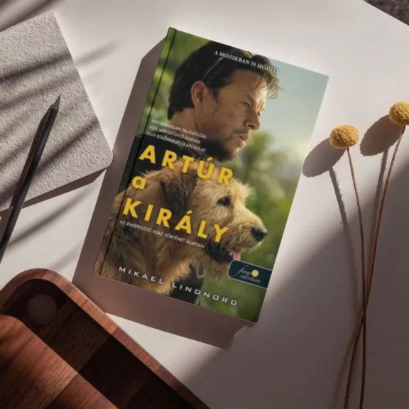 A képen az Artúr a király című könyv látható a háttérben egy férfi és egy kutya alakja.