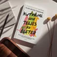A képen a Kutyával lesz teljes az életed című könyv látható a háttérben egy kutyával.