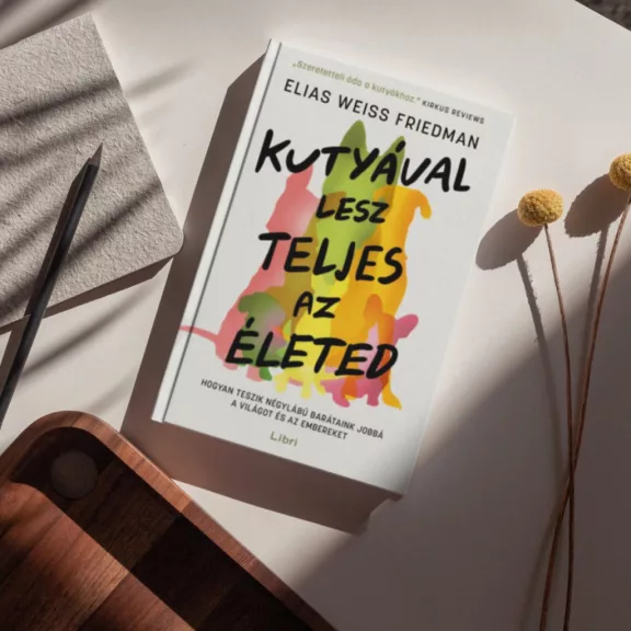 A képen a Kutyával lesz teljes az életed című könyv látható a háttérben egy kutyával.