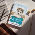 A képen a Cooper története című könyv látható a háttérben egy husky.