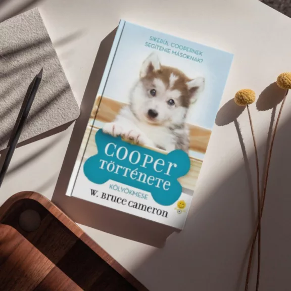A képen a Cooper története című könyv látható a háttérben egy husky.