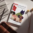 A képen a Kötött kutyadivat című könyv látható a háttérben egy kötött kabátot viselő kutyával.