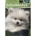 A képen a Kölyökkutya 1x1 kalauz című könyv látható a háttérben egy pomerániai törpespicc.