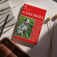 A képen A dalmata című könyv látható kutyás témájú háttérrel.